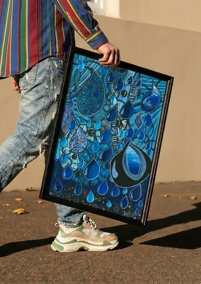 Blue Raindrops by JHN.ByHjort carried in a black frame along a sunny street
