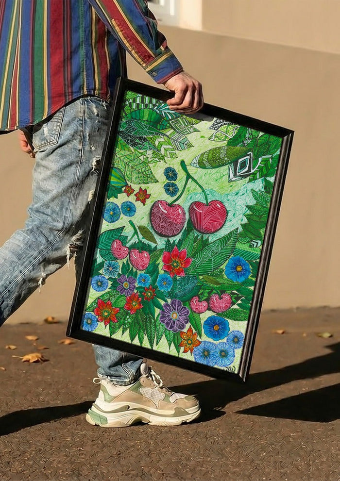 Cherries and Blue Flowers by JHN.ByHjort carried in a black frame along a sunny street