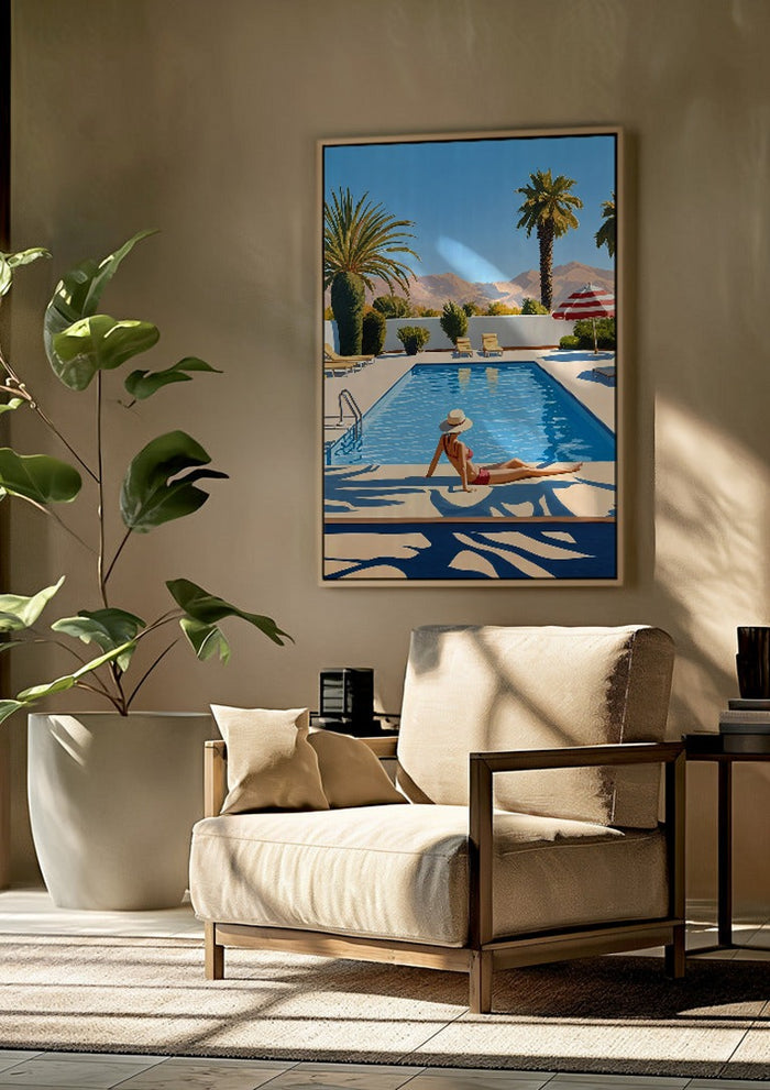 Poolside Afternoon by Elena Avanesova framed above a beige armchair beside a potted plant