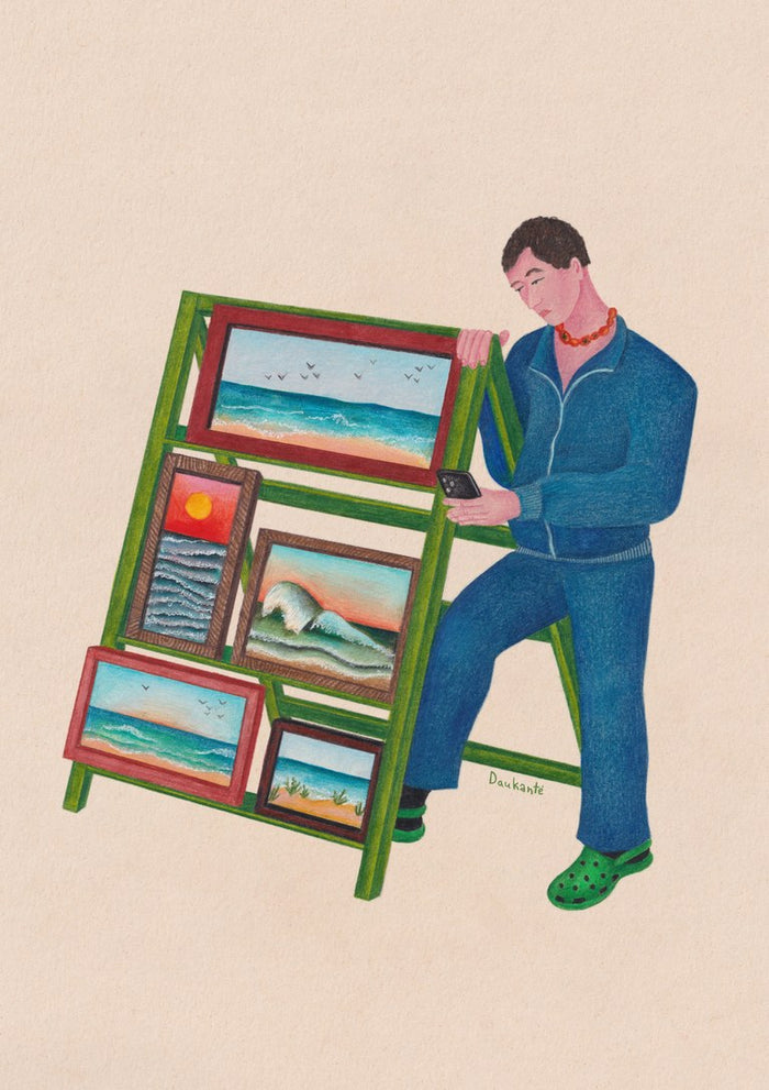 Seaside side hustle by Daukantė, a man on his phone beside a green stall of small framed seascapes