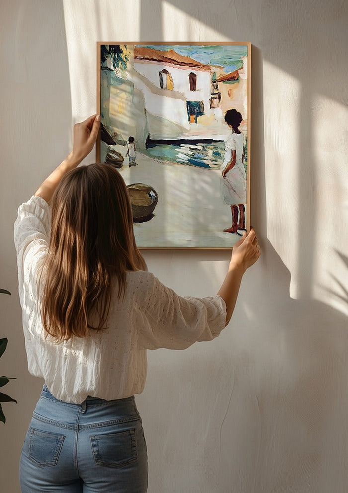 Village Street by Elena Avanesova being hung on a sunlit wall