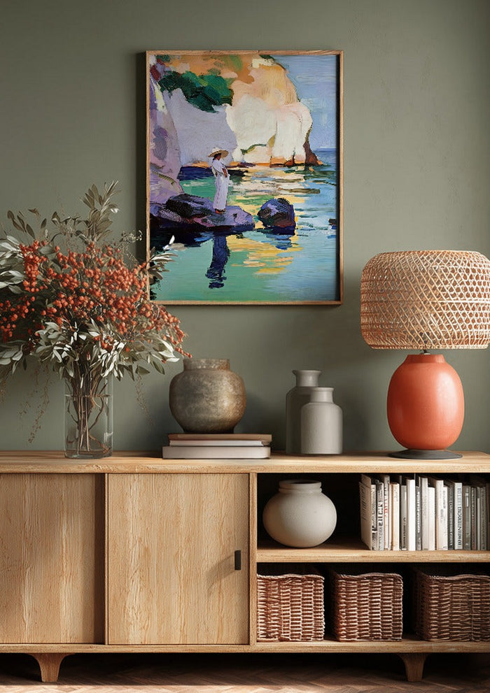 Woman by the Cliffs by Elena Avanesova above a wooden sideboard on a sage green wall